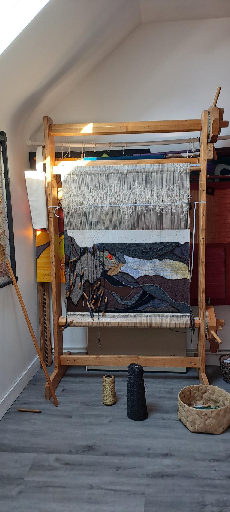 Le métier de haute lice vertical de l'atelier, une tapisserie paysage en cours de tissage